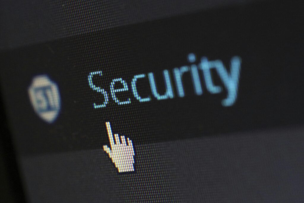 A computer screen showing the word "Security" with a pixelated cursor hand icon hovering over it, emphasizing cybersecurity.
